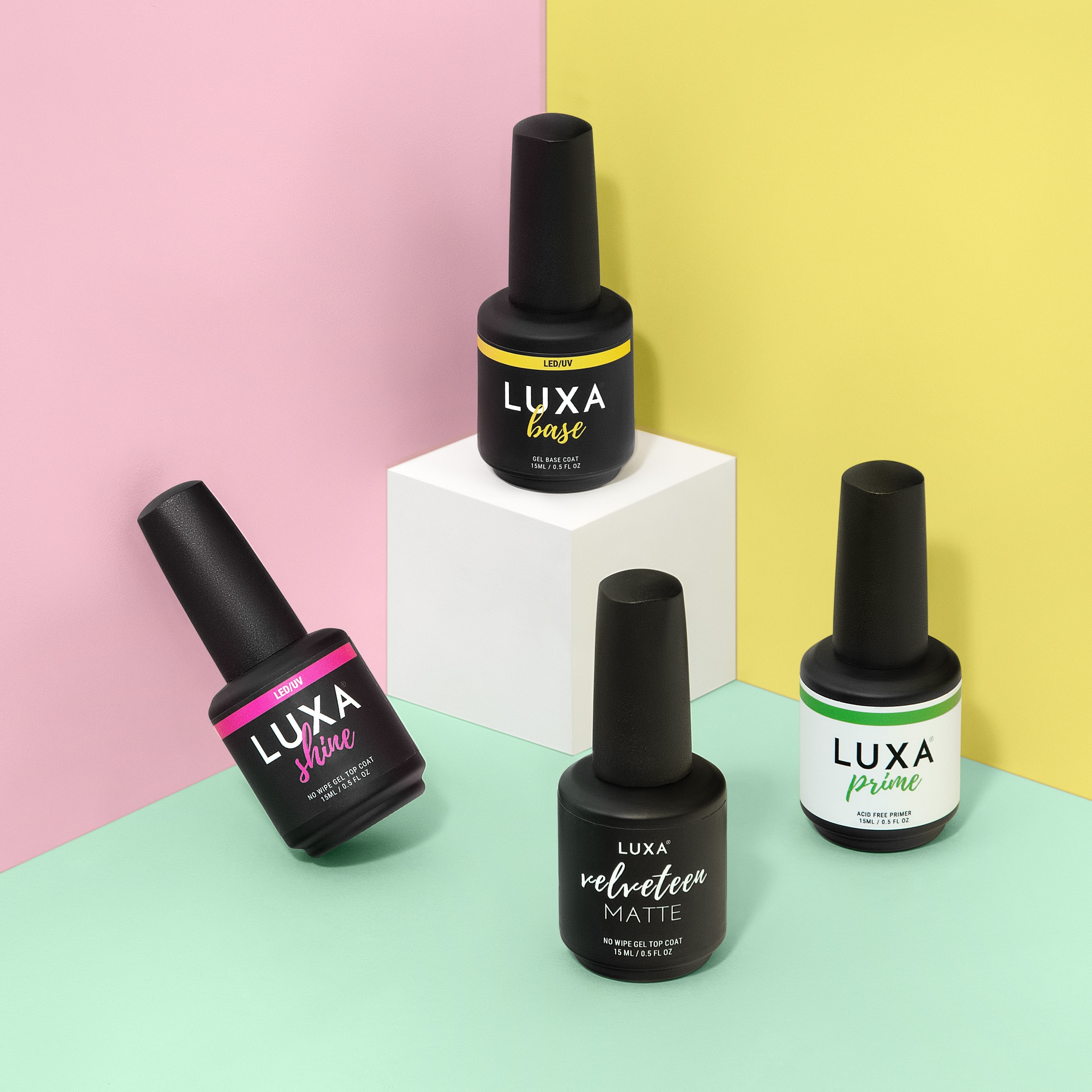 Front view of LUXA gel polish bottles showcasing Base and Velveteen Matte labels on pastel pink, yellow, and mint background
